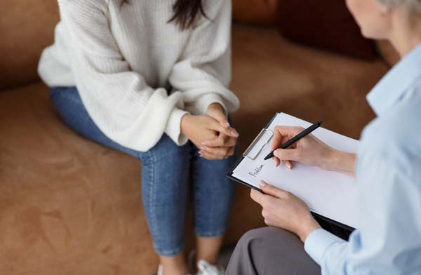 Unrecognizable,Psychologist,Talking,With,Female,Client,Taking,Notes,During,Psychotherapy
